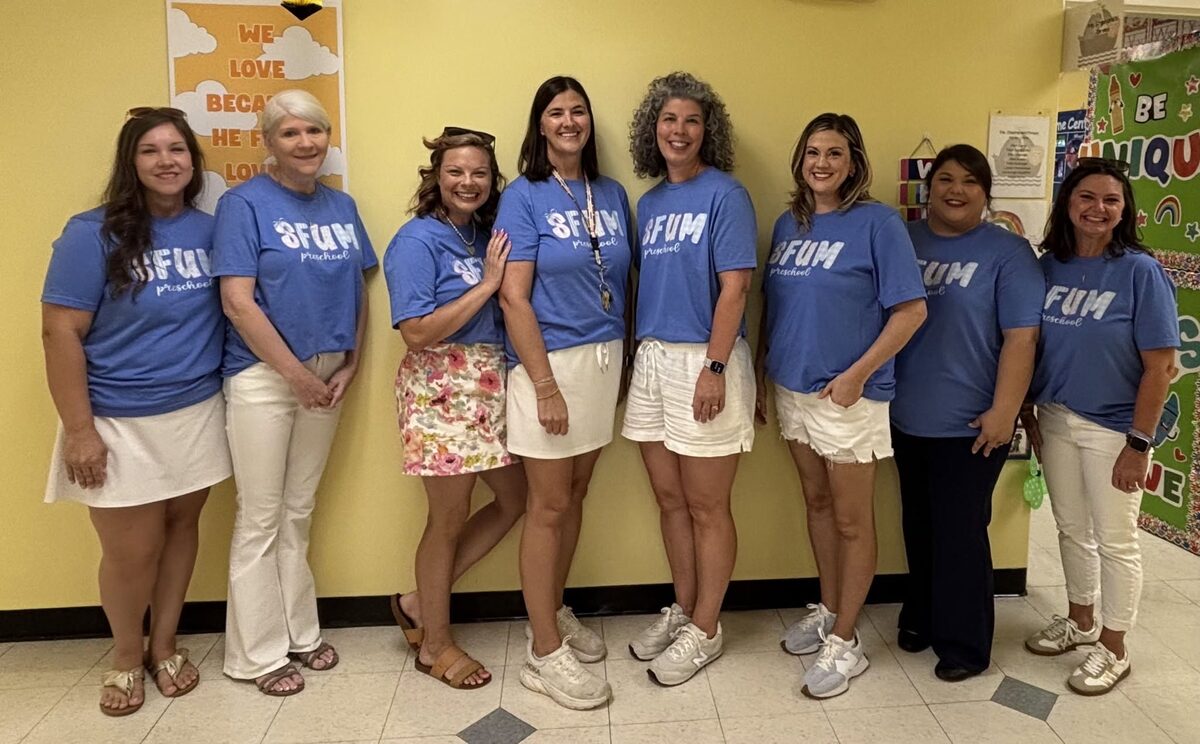 The SFUM Preschool staff together in a preschool hallway