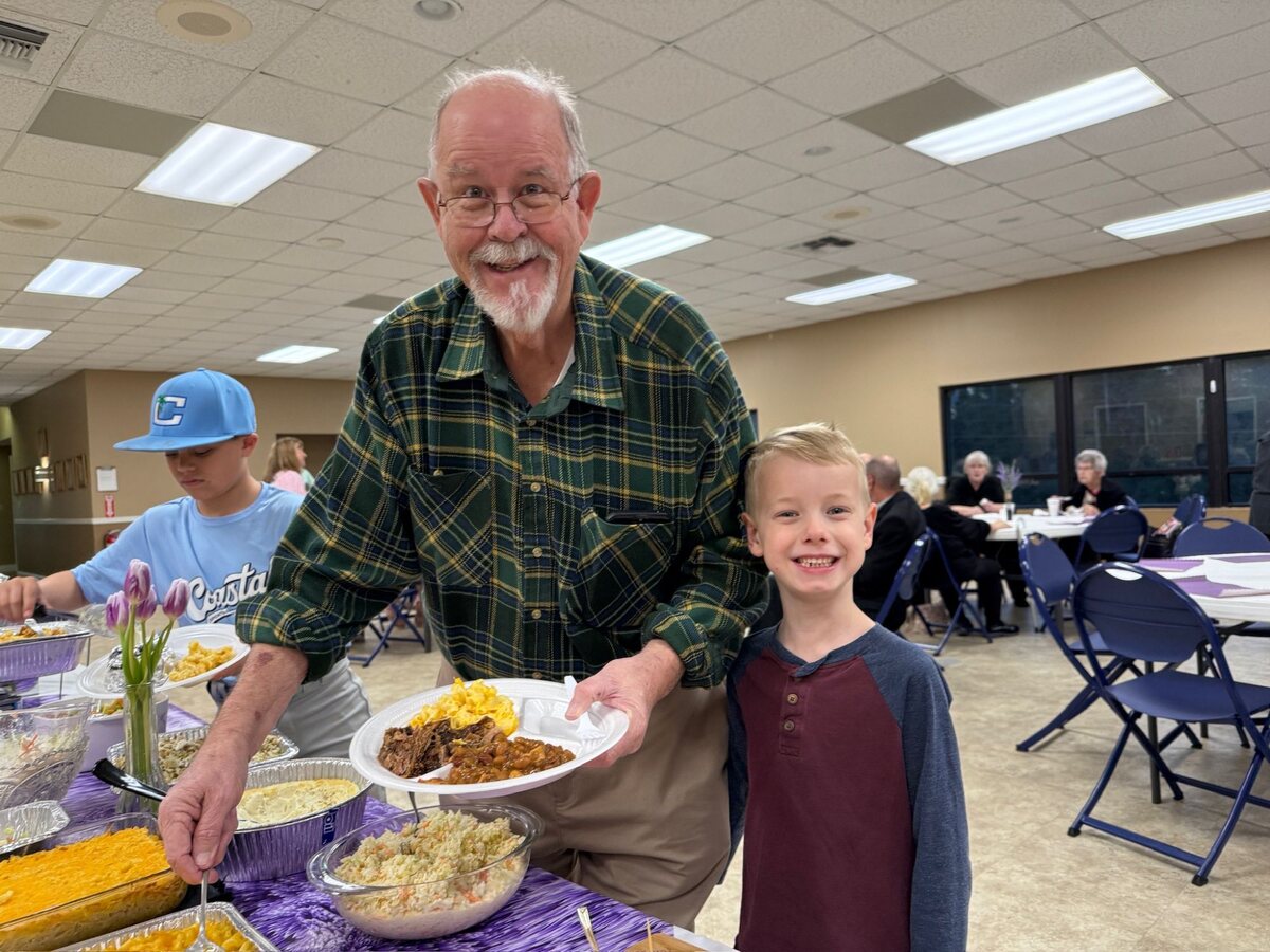 A grandfather and grandson at the fellowship table